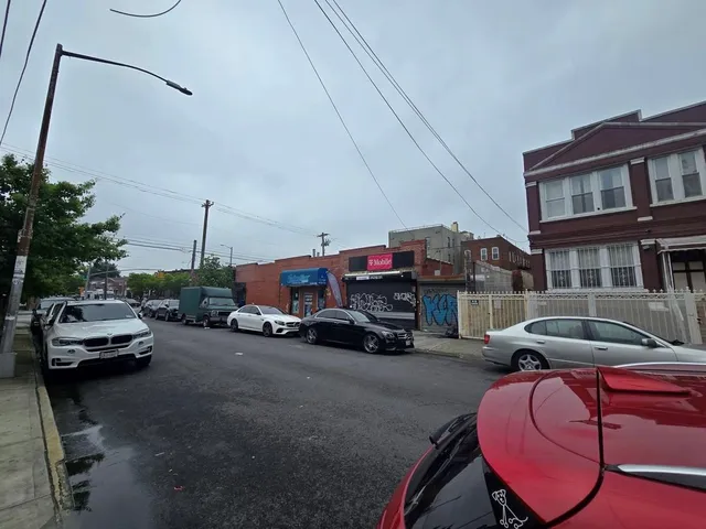 a view of a city street with a cars parked on the road