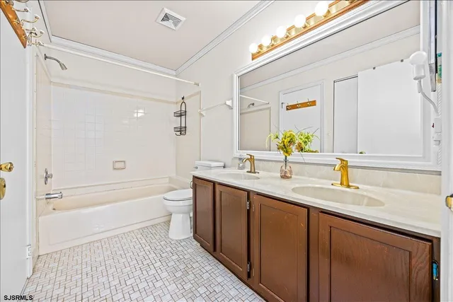 a bathroom with a double vanity sink toilet and shower