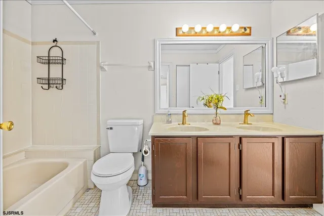 a bathroom with a granite countertop toilet sink and mirror