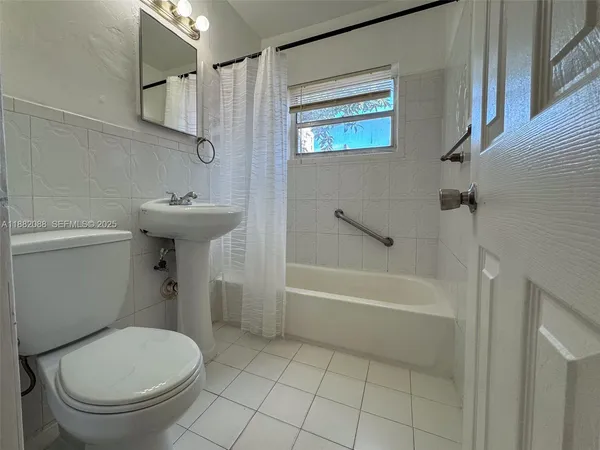 a view of a utility room with wooden floor cabinet and a window
