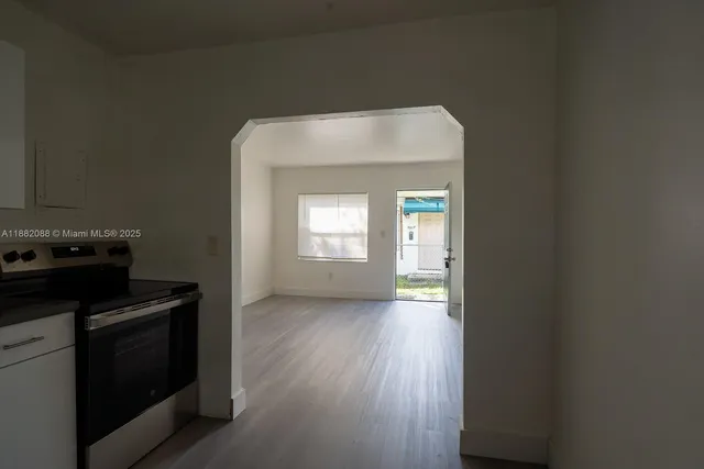 a view of a utility room with wooden floor cabinet and a window
