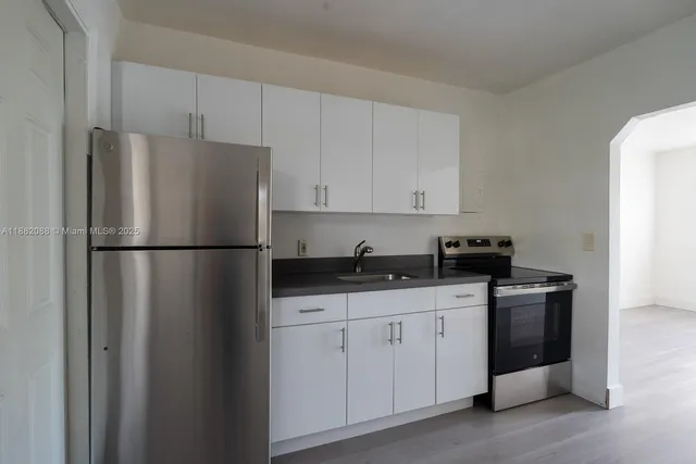 a kitchen with appliances a sink and cabinets