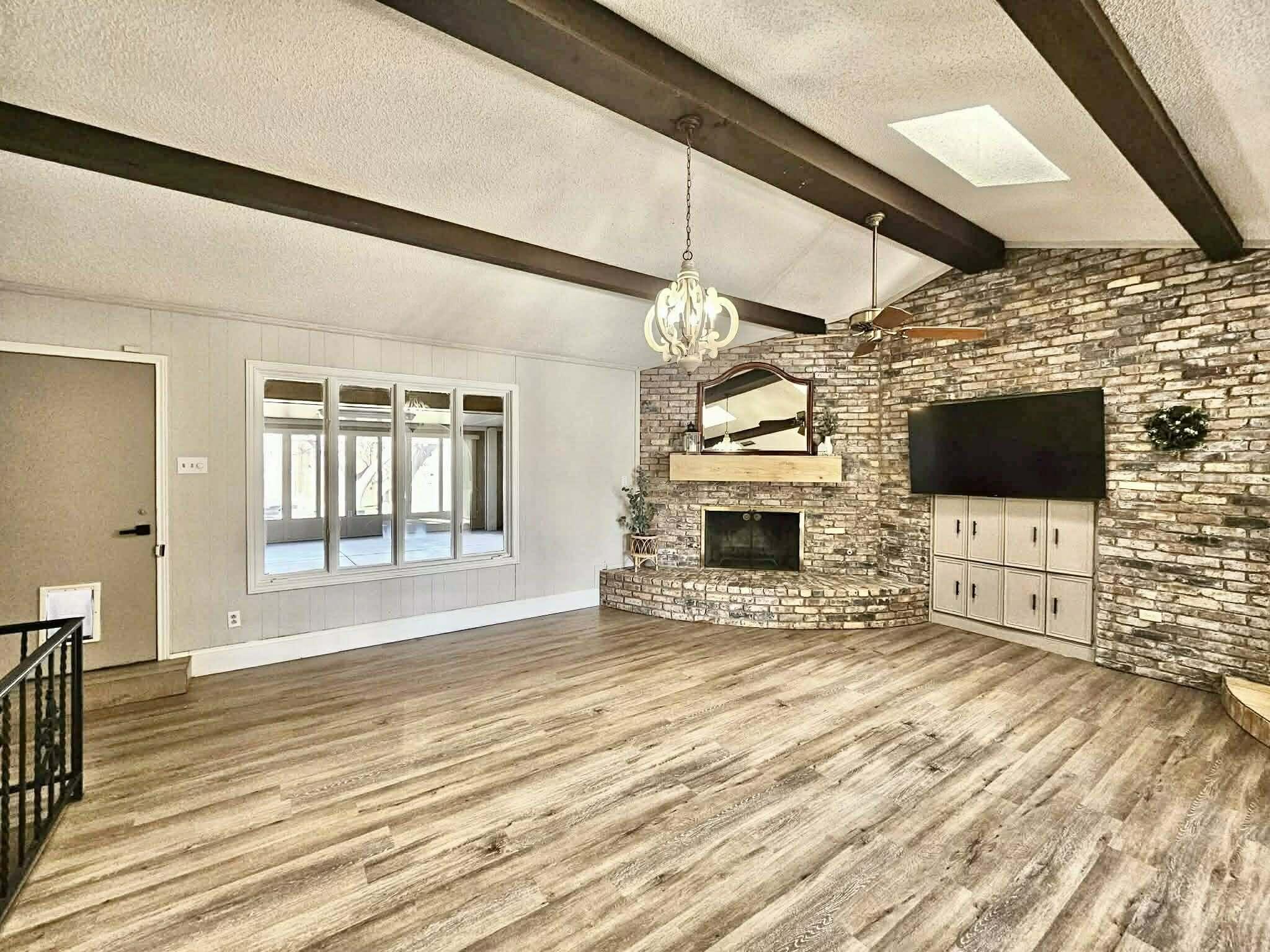 3710 75th Street Lubbock, TX 79423 - Photo 4 of 36 a view of a livingroom with an empty space and a fireplace