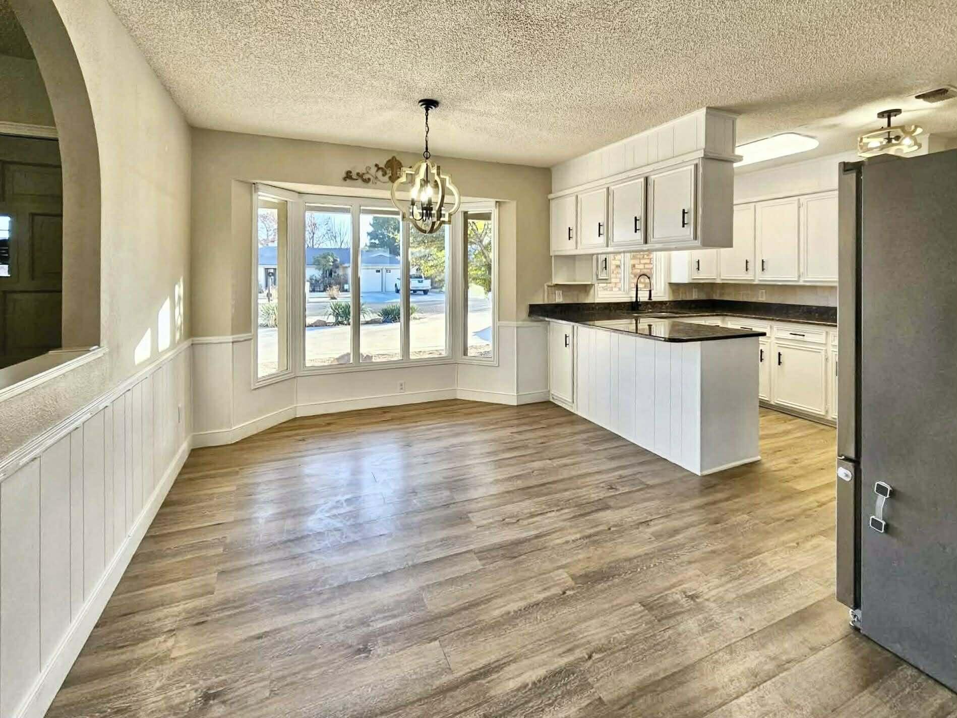 3710 75th Street Lubbock, TX 79423 - Photo 6 of 36 a large kitchen with cabinets wooden floor and stainless steel appliances