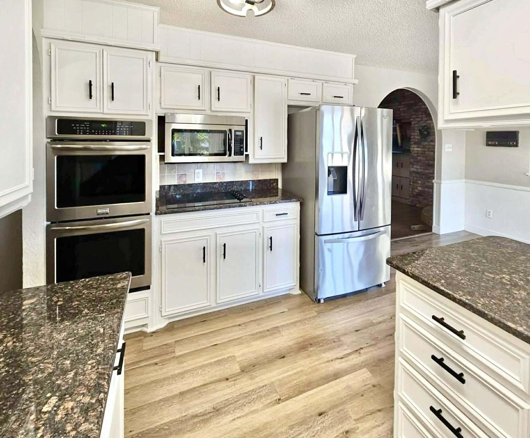 3710 75th Street Lubbock, TX 79423 - Photo 8 of 36 a kitchen with granite countertop a refrigerator and a stove