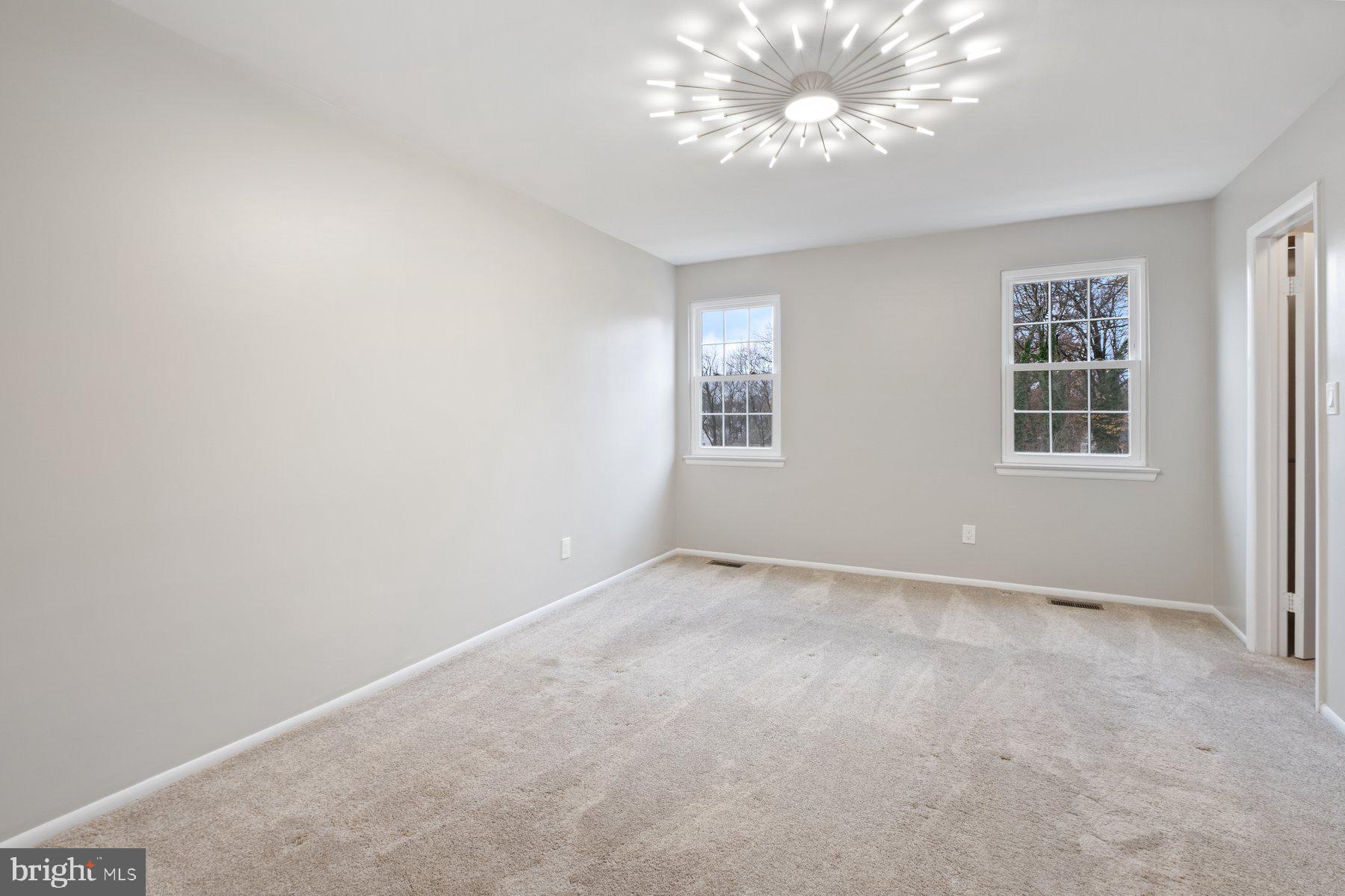 3030 Piano Lane, Unit 56 Silver Spring, MD 20904 - Photo 13 of 28 an empty room with windows and chandelier fan