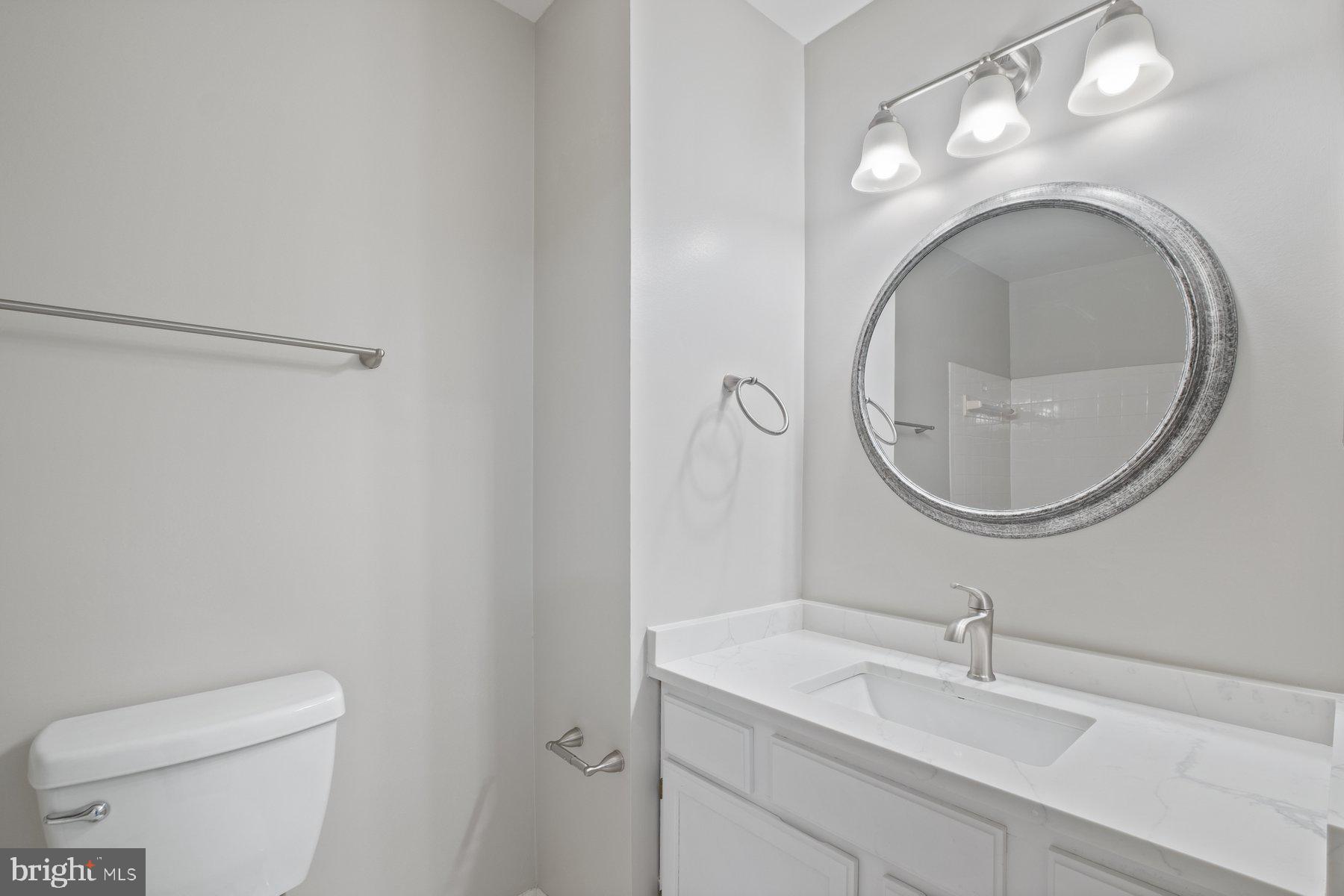 3030 Piano Lane, Unit 56 Silver Spring, MD 20904 - Photo 17 of 28 a bathroom with a toilet a sink and a mirror