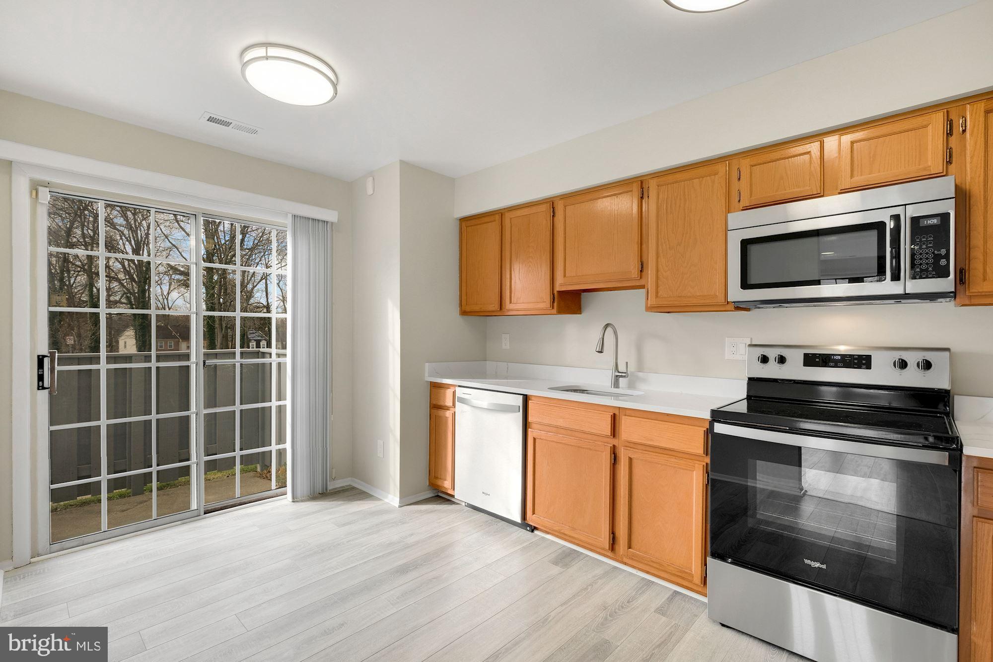 3030 Piano Lane, Unit 56 Silver Spring, MD 20904 - Photo 7 of 28 a kitchen with stainless steel appliances a stove a sink and a microwave