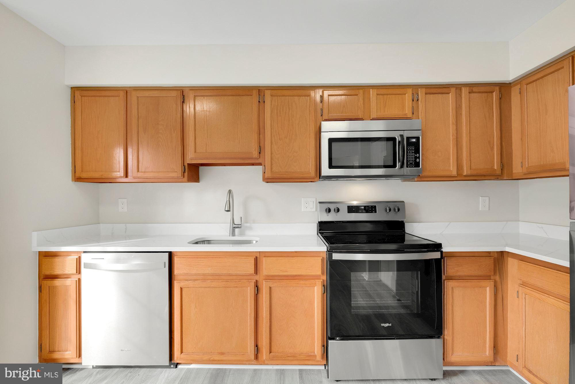 3030 Piano Lane, Unit 56 Silver Spring, MD 20904 - Photo 8 of 28 a kitchen with stainless steel appliances a stove a microwave sink and cabinets