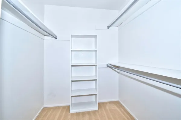 a view of walk in closet with empty racks