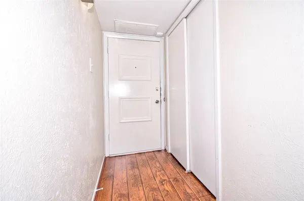 a view of a hallway with wooden floor