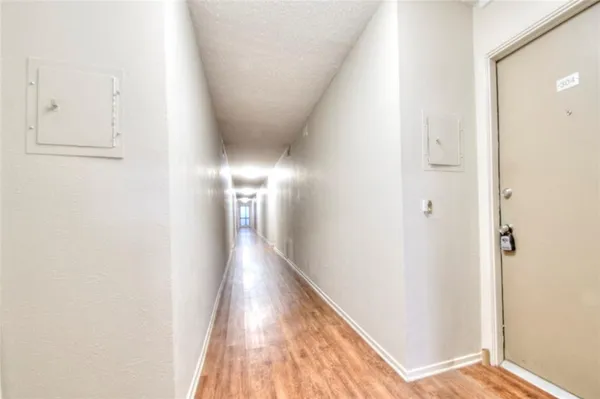 a view of a hallway with wooden floor