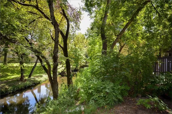 a view of a house with large trees and a small yard