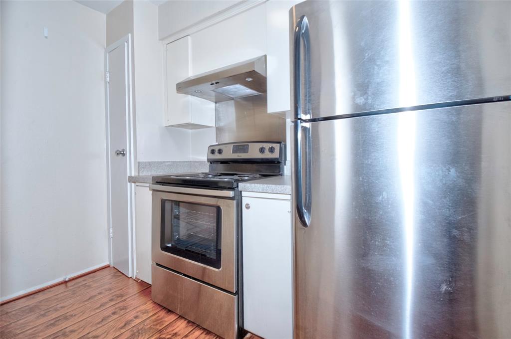 4837 Cedar Springs Road, Unit 304 Dallas, TX 75219 - Photo 4 of 32 a kitchen with a refrigerator and a stove top oven