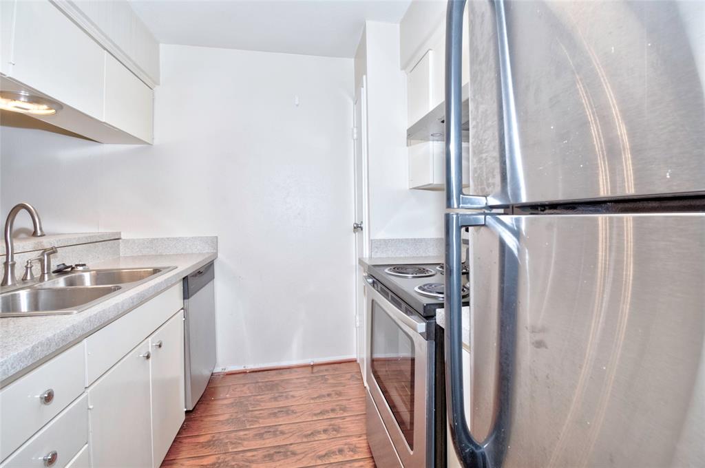 4837 Cedar Springs Road, Unit 304 Dallas, TX 75219 - Photo 6 of 32 a kitchen with a sink a refrigerator and cabinets