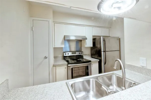 a kitchen with a refrigerator sink and stainless steel appliances