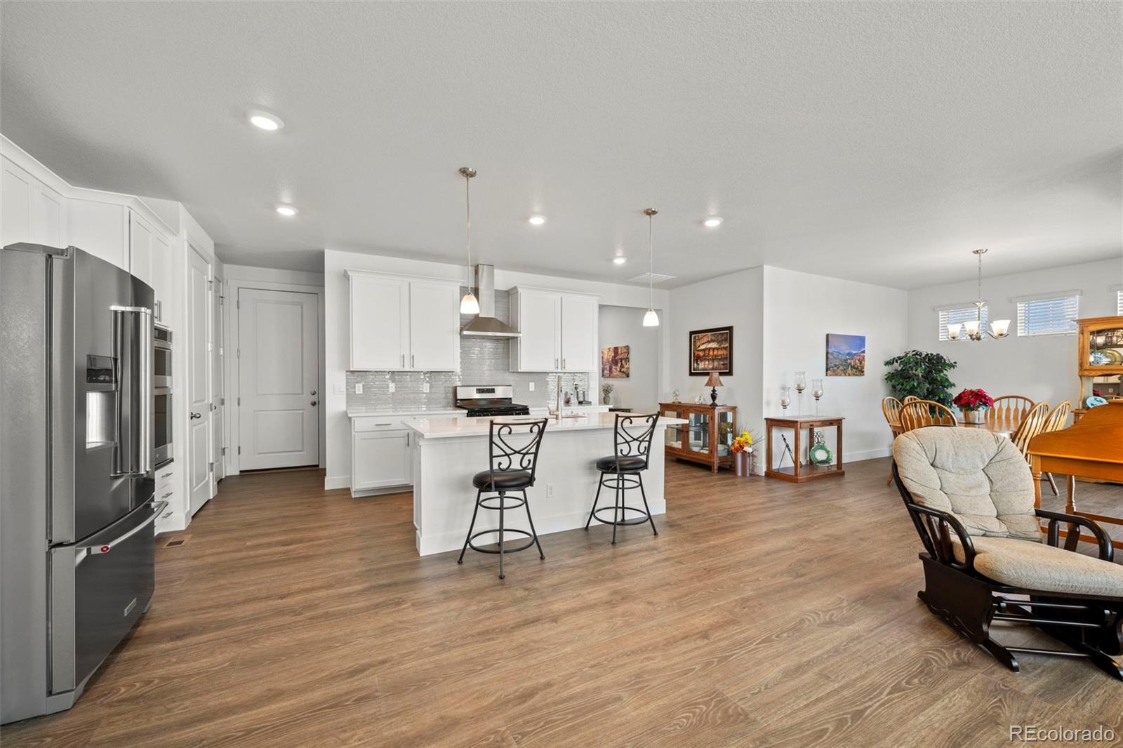 1680 Rivergate Way Berthoud, CO 80513 - Photo 11 of 41 a living room with furniture dining table and wooden floors