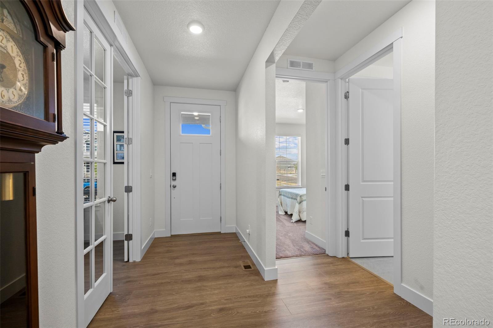 1680 Rivergate Way Berthoud, CO 80513 - Photo 3 of 41 a view of a hallway with wooden floor and staircase