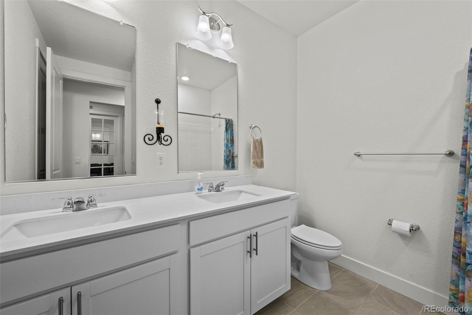 1680 Rivergate Way Berthoud, CO 80513 - Photo 6 of 41 a bathroom with a toilet a sink a mirror and vanity