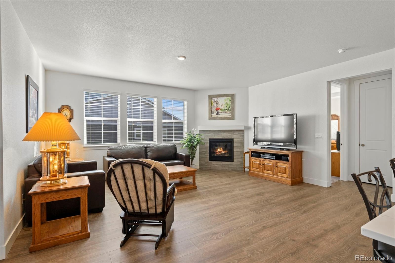 1680 Rivergate Way Berthoud, CO 80513 - Photo 8 of 41 a living room with furniture a fireplace and a flat screen tv
