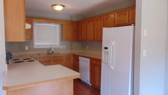 a kitchen with a refrigerator sink and cabinets