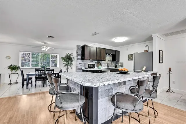 a kitchen with granite countertop stainless steel appliances a sink stove and microwave
