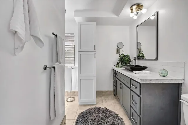 a bedroom with a bed and a lamp on dresser