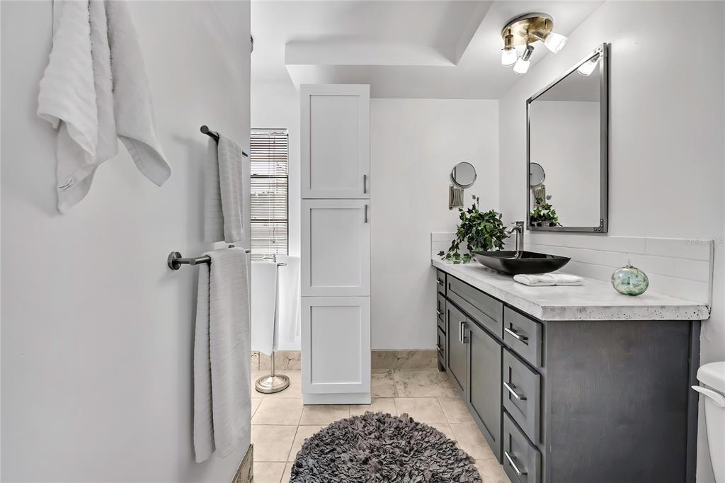 9059 Gaynor Street Spring Hill, FL 34608 - Photo 21 of 36 a bathroom with a granite countertop sink a toilet and shower