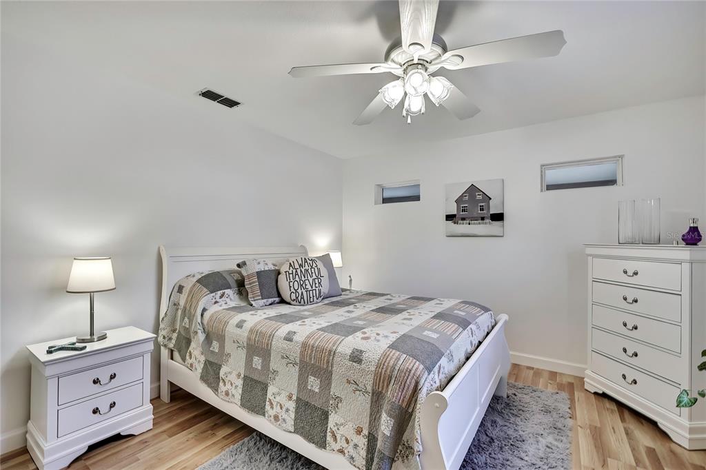 9059 Gaynor Street Spring Hill, FL 34608 - Photo 26 of 36 a bedroom with a bed and a lamp on dresser