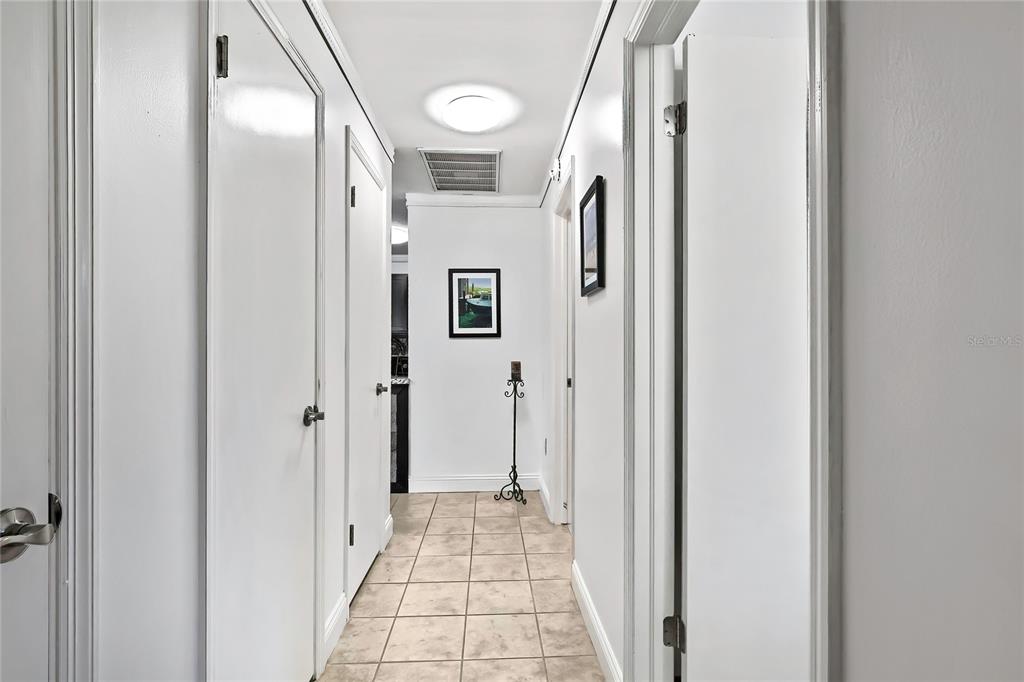 9059 Gaynor Street Spring Hill, FL 34608 - Photo 29 of 36 a view of a hallway with wooden floor and a bathroom