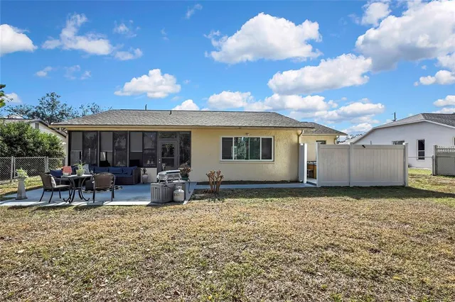 a view of house with backyard and sitting area