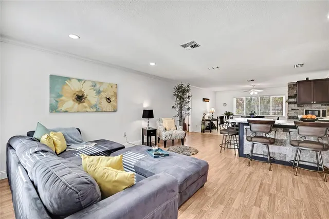 a living room with lots of furniture and kitchen view