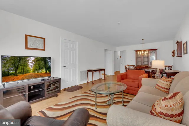 a living room with furniture a flat screen tv and floor to ceiling window