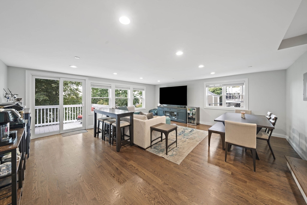 a living room with furniture a large window and wooden floor
