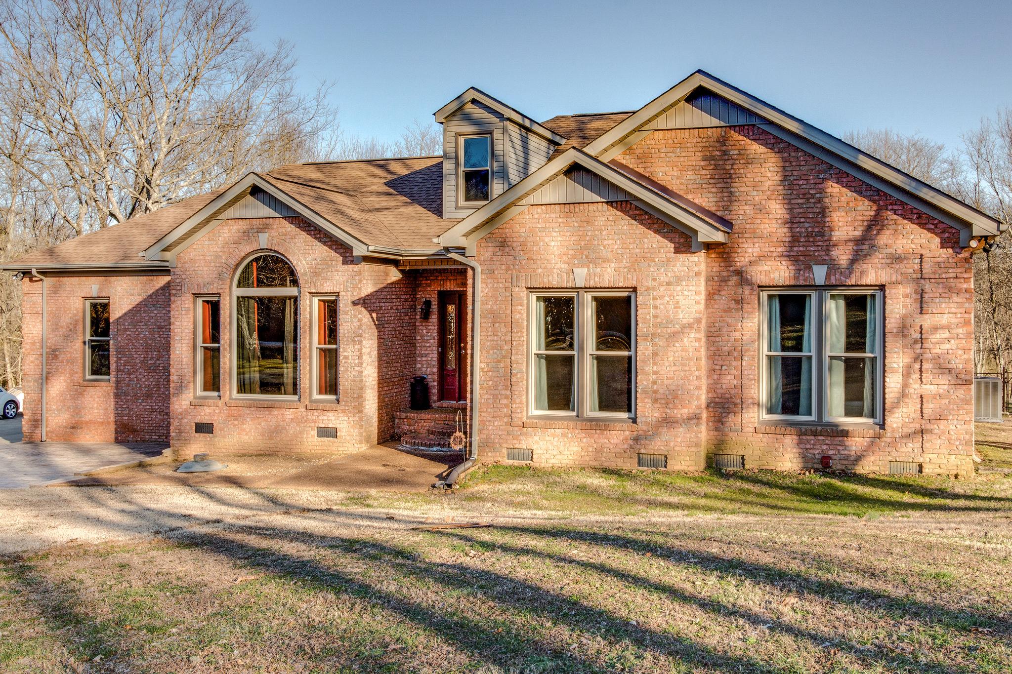 1040 Rip Steele Road Columbia, TN 38401 - Photo 2 of 25 a view of a brick house with large windows and a road