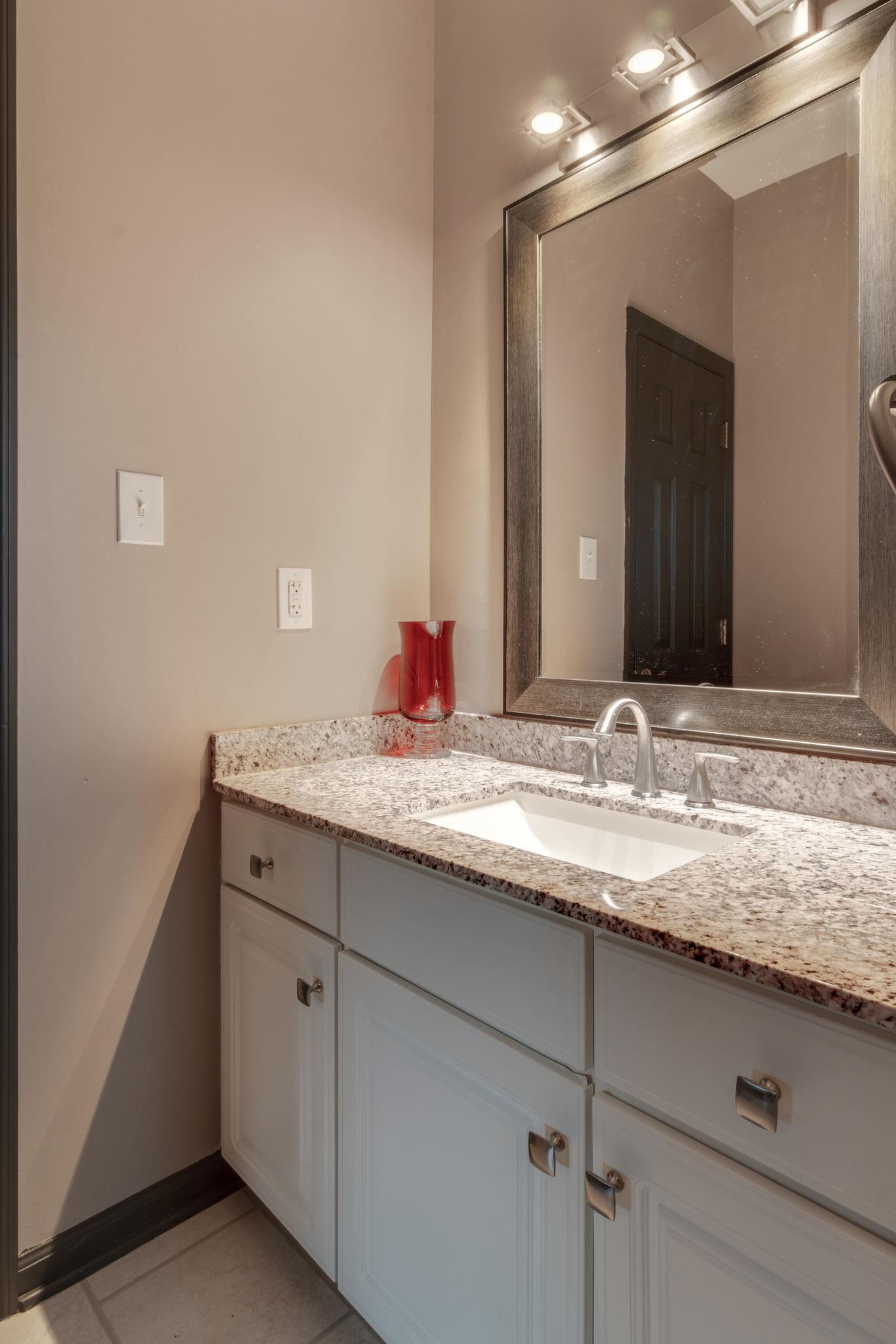 1040 Rip Steele Road Columbia, TN 38401 - Photo 18 of 25 a bathroom with a granite countertop sink and a mirror