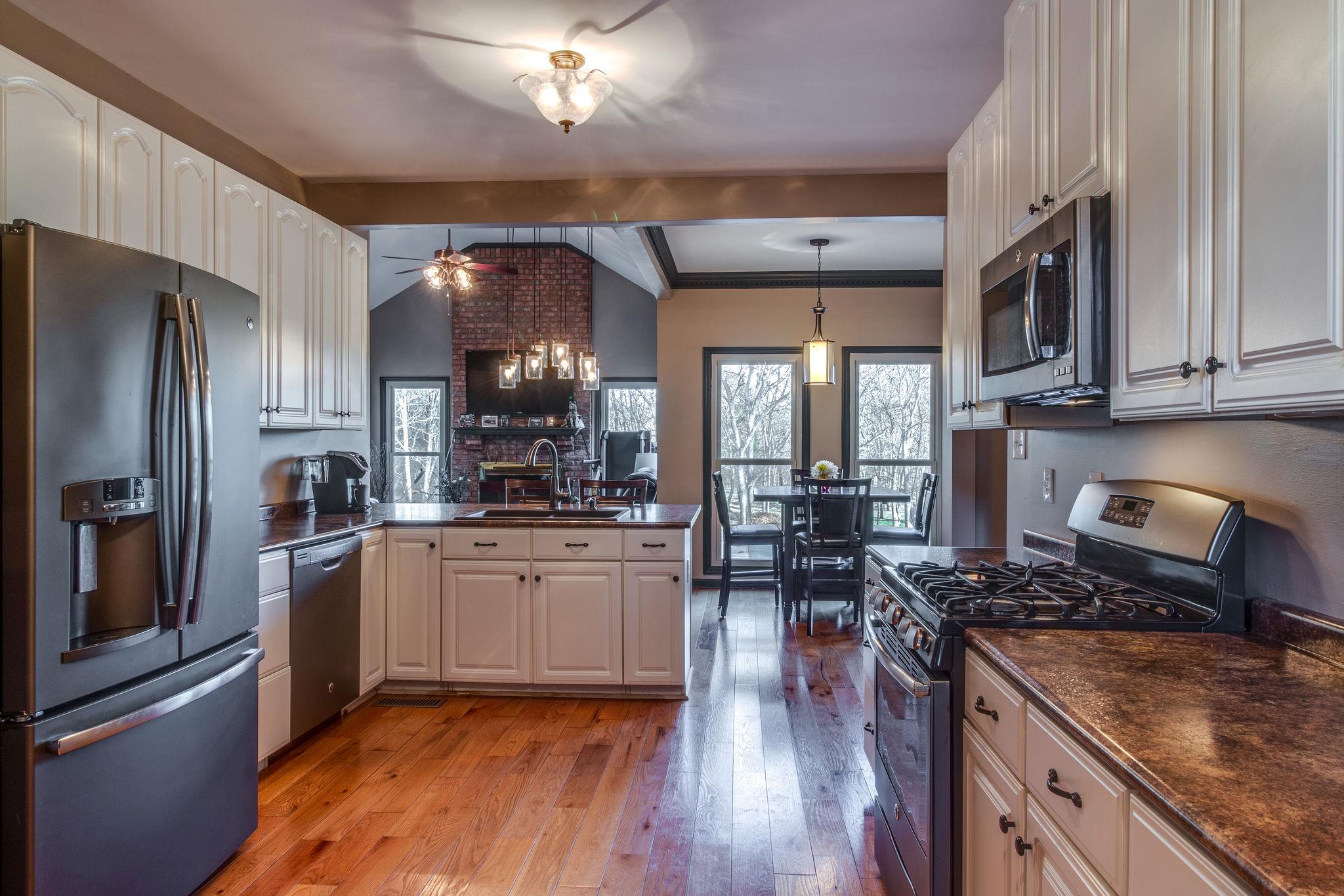 1040 Rip Steele Road Columbia, TN 38401 - Photo 7 of 25 a kitchen with stainless steel appliances granite countertop a stove top oven a refrigerator a sink and dishwasher with wooden floor