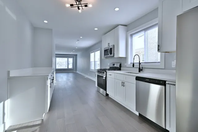 a kitchen with sink a refrigerator and cabinets