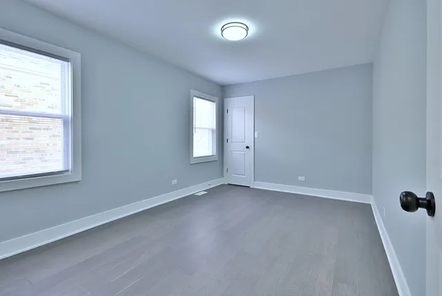 an empty room with windows and closet
