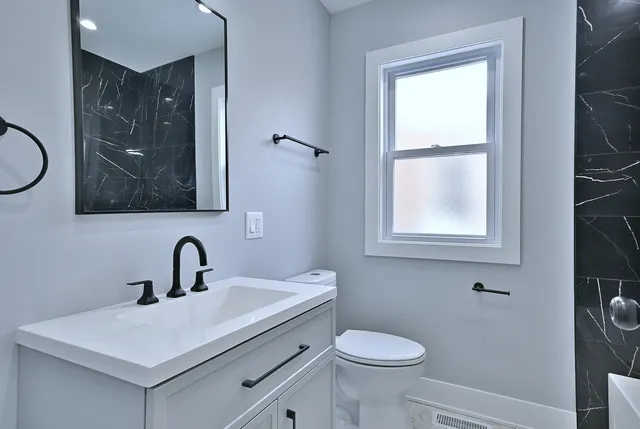 a bathroom with a toilet sink and mirror