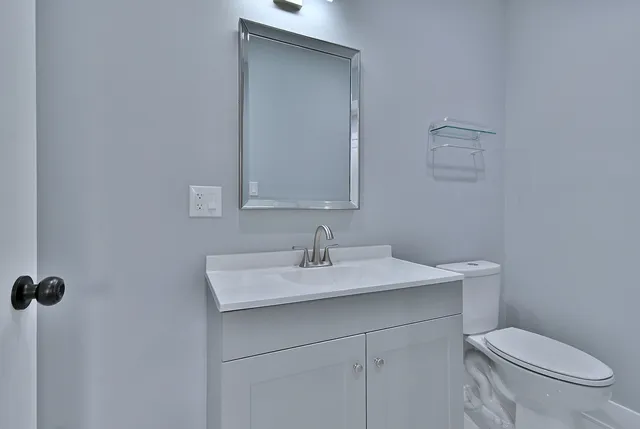 a bathroom with a sink toilet and mirror