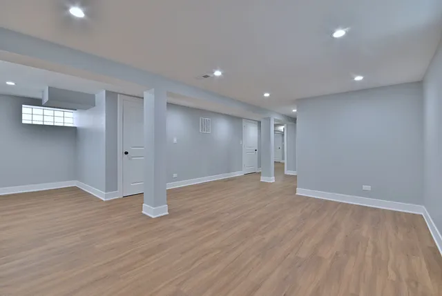 a view of an empty room with wooden floor