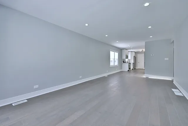 an empty room with cabinet and windows