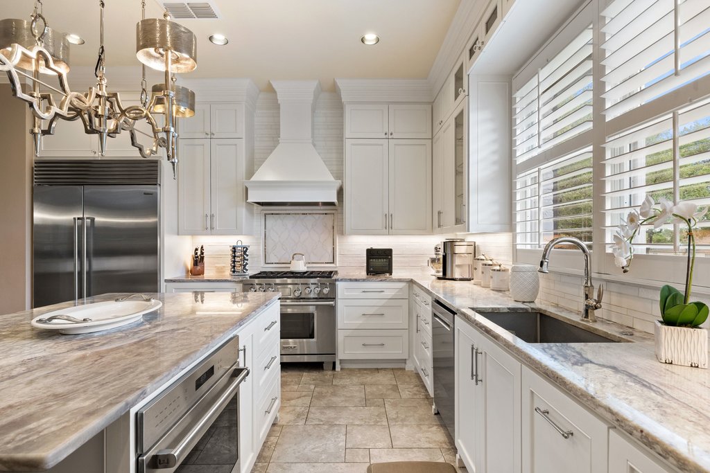 7609 Sandia Loop Austin, TX 78735 - Photo 13 of 40 Gourmet kitchen featuring white cabinetry, stone countertops, stainless steel appliances, a large center island, and a built-in oven
