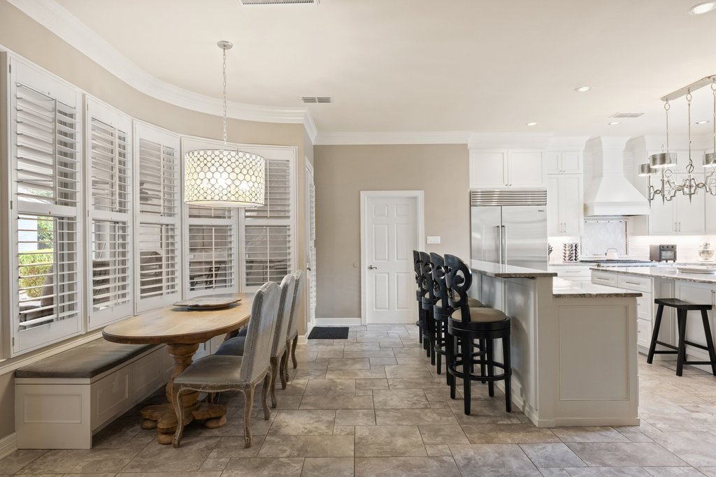 7609 Sandia Loop Austin, TX 78735 - Photo 14 of 40 The breakfast nook features a custom built-in bench and large bay windows with plantation shutters, offering a relaxed setting for casual meals just off the kitchen.