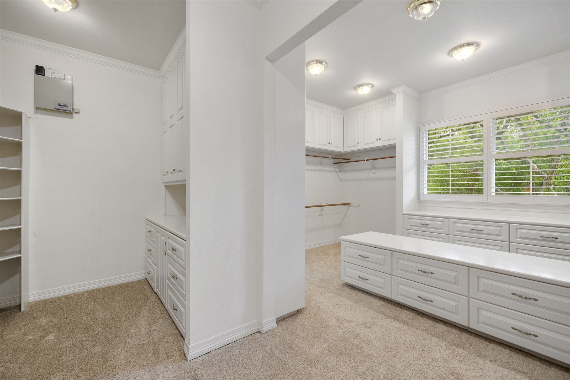 7609 Sandia Loop Austin, TX 78735 - Photo 21 of 40 Walk-in closet featuring extensive built-in white cabinetry, integrated shelving, and a central island with storage