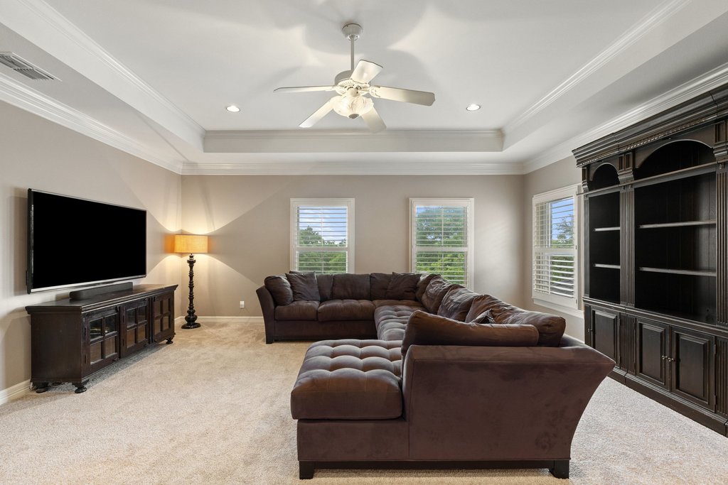 7609 Sandia Loop Austin, TX 78735 - Photo 24 of 40 The expansive upstairs landing functions as a versatile secondary living area or media room, complete with tray ceilings and elevated views of the property’s lush surroundings.