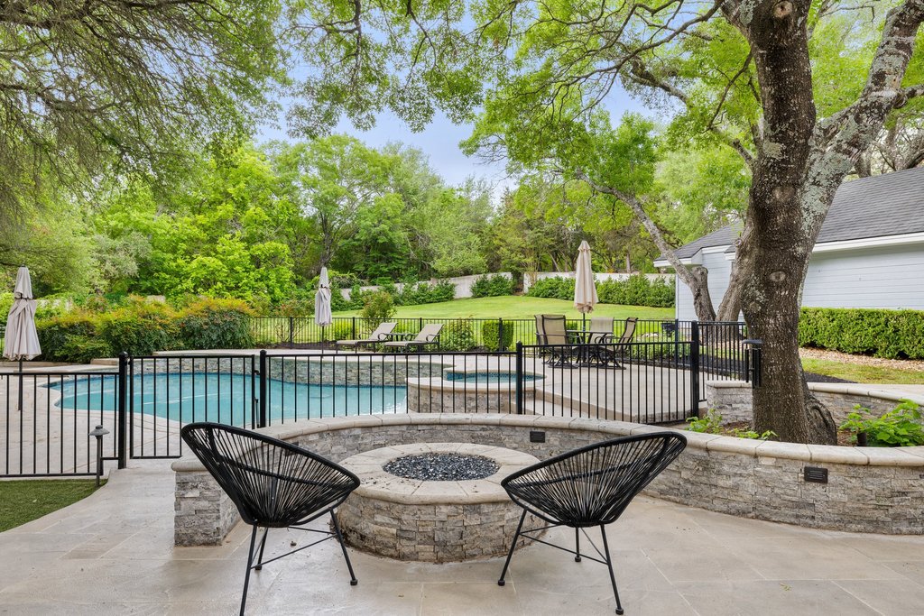 7609 Sandia Loop Austin, TX 78735 - Photo 29 of 40 A custom stone fire pit offers an inviting spot for evening gatherings, perfectly positioned to enjoy views of the pool and the home's sprawling, park-like grounds.