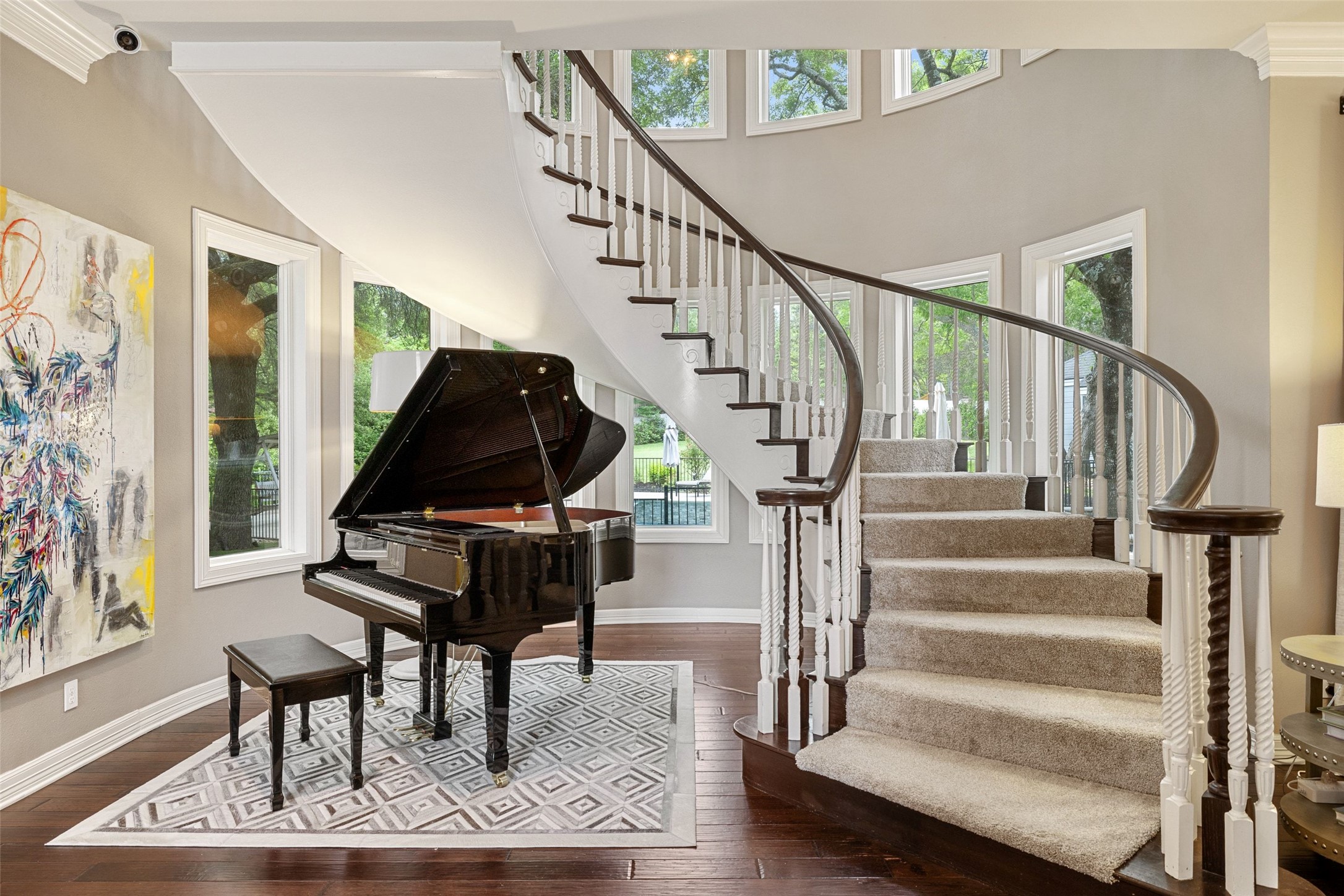 7609 Sandia Loop Austin, TX 78735 - Photo 3 of 40 Gracious curved staircase with dark wood handrails and white balusters