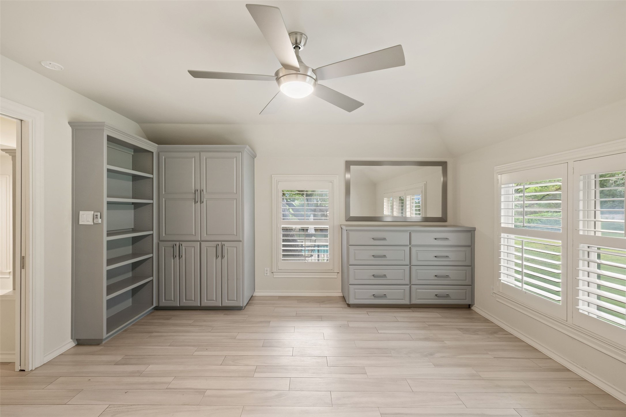 7609 Sandia Loop Austin, TX 78735 - Photo 36 of 40 Spacious room featuring light wood-finish flooring, a contemporary ceiling fan with integrated lighting, and multiple windows with plantation shutters